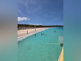 A lively scene at a beautiful beach with a group enjoying the clear turquoise waters — perfect for a sandbar stop and fun in the sun.