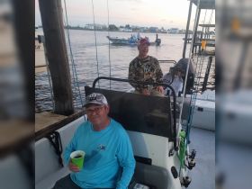 A group of friends enjoys a fishing trip on a boat, capturing the essence of camaraderie and adventure on the water.
