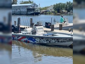 A fishing boat docked at the marina, showcasing its vibrant design and fishing gear, perfect for anglers looking to explore the waters.