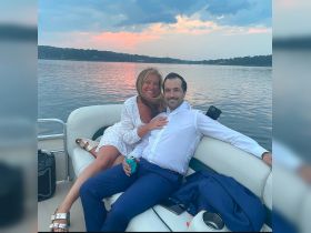 A couple enjoys a romantic moment on a boat at sunset, sharing drinks and smiles — perfect for special occasions or sunset cruises.