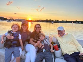 A joyful family enjoys a sunset cruise on a boat, capturing a perfect moment of togetherness and celebration on the water.