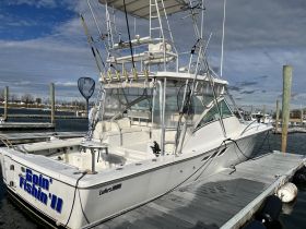 A well-equipped fishing boat named 'Goin' Fishin' II' docked at the marina, showcasing its sturdy design and fishing gear, perfect for a day on the water.