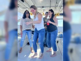 A lively group enjoys a fun moment aboard a boat, celebrating with drinks and laughter — perfect for memorable outings on the water.