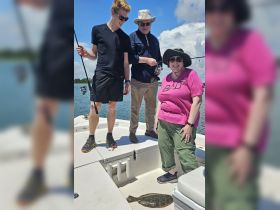 A group of friends enjoys a fishing trip on a boat, showcasing their catch of the day. Perfect for outdoor enthusiasts and fishing adventures.