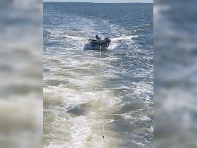 A small boat is being towed through the water, showcasing the dynamic activity of boating. Ideal for those interested in water sports and towing experiences.