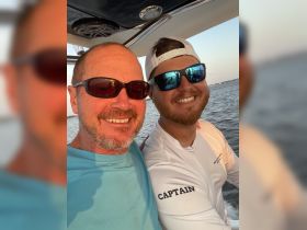 Two friends enjoy a joyful moment on a boat, capturing the essence of a fun day on the water with smiles and camaraderie.