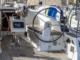 A detailed view of the helm area inside a sailboat, showcasing the steering wheel and navigation console, perfect for those looking to explore the seas.