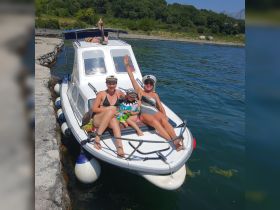 A joyful family enjoys a sunny day on a boat, capturing the essence of summer fun and togetherness on the water.