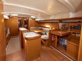 Interior view of a well-appointed boat cabin featuring comfortable seating and a functional helm area, perfect for relaxing or navigating on the water.
