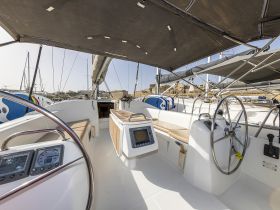 An inviting view of the helm area inside a sailboat, showcasing the console and seating, perfect for navigating the open waters.