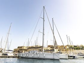 A beautiful yacht docked at the marina, showcasing its elegant design against a clear sky — perfect for luxury sailing experiences.