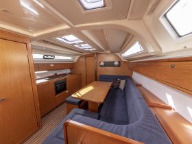 Interior view of a well-appointed boat cabin featuring a cozy seating area and kitchen amenities, perfect for comfortable cruising and relaxation on the water.