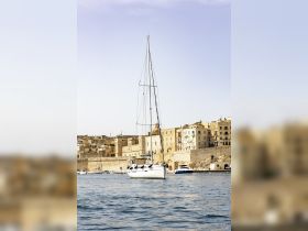A picturesque sailboat docked in Malta, showcasing the stunning coastal architecture in the background — perfect for sailing enthusiasts and travelers.