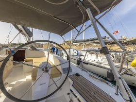 A detailed view of the helm area inside a sailboat, showcasing the steering wheel and seating, perfect for navigating the open waters.