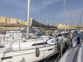 A picturesque view of multiple yachts docked in a marina, showcasing their sleek designs against a backdrop of historic buildings.