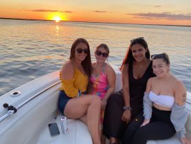 A group of friends enjoys a beautiful sunset on a boat, capturing the perfect moment for a memorable outing on the water.