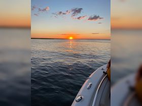 A stunning sunset view from a boat, capturing the tranquil waters and vibrant sky, perfect for romantic evenings or peaceful retreats on the water.