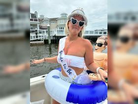 A bride-to-be celebrates her upcoming wedding with a fun party on the water, complete with festive attire and inflatable decorations — perfect for bachelorette festivities.