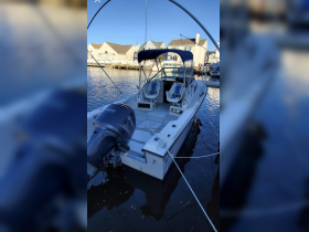 A clear view of a center console boat docked, showcasing its sleek design and spacious layout — perfect for fishing or leisure outings.