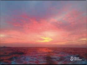 A breathtaking sunset over the ocean, showcasing vibrant colors reflecting on the water — a perfect backdrop for evening boat cruises.