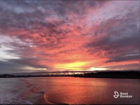 A stunning sunset paints the sky in vibrant hues over calm waters, creating a picturesque scene perfect for evening boat cruises.