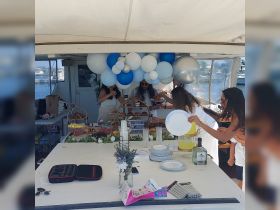 A vibrant setup for a party on a boat featuring a variety of food and drinks, perfect for celebrations and gatherings on the water.
