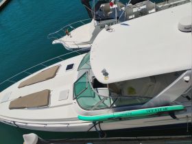 Aerial view of a sleek yacht docked, showcasing its spacious deck and luxurious features, perfect for relaxing on the water.