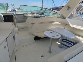 A spacious interior view of a boat's helm and seating area, showcasing comfortable seating and a well-equipped cabin, perfect for relaxing on the water.