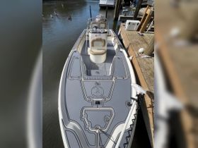 A detailed view of the helm and seating area inside a boat, showcasing the modern console and comfortable seating, perfect for a day on the water.