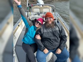 A cheerful couple enjoys their time on a boat, showcasing the joy of outdoor adventures on the water.