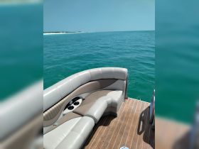 A comfortable seating area inside a boat, featuring plush cushions and cup holders, perfect for relaxing while enjoying the scenic views of the turquoise waters.
