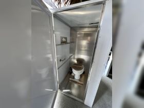 Interior view of a clean and functional boat bathroom, featuring a toilet and stainless steel finishes, ideal for comfort during boating trips.