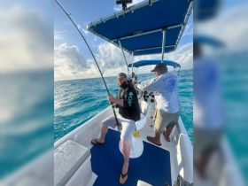 A group of friends enjoys a fishing trip on a boat, showcasing the excitement of ocean adventures and camaraderie on the water.