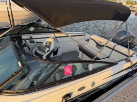 A detailed view of the interior helm and seating area of a sleek boat, showcasing modern design and comfort for an enjoyable boating experience.