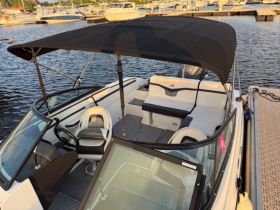 Interior view of a stylish boat helm and seating area, showcasing comfortable amenities for a relaxing day on the water.