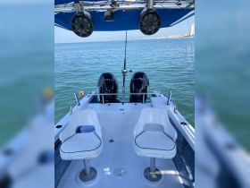 Interior view of a boat's helm area featuring comfortable seating and modern audio equipment, perfect for a day out on the water.