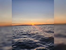 A stunning sunset over tranquil waters, capturing the serene beauty of nature — perfect for romantic evenings or peaceful boat rides.