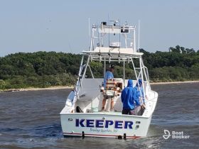 A group of anglers aboard the 'Keeper' boat, actively fishing in the waters near Bowleys Quarters, MD — perfect for a day of adventure on the water.