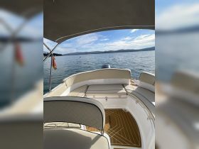 A stylish interior view of a boat's seating area, showcasing comfortable cushions and a sleek design, perfect for relaxing on the water.