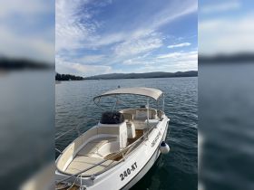 A sleek speedboat named '240-KT' docked in calm waters, perfect for exploring scenic coastlines or enjoying a day on the water.