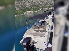 A sleek speedboat docked in tranquil waters, showcasing its modern design and comfortable seating — perfect for exploring coastal destinations.