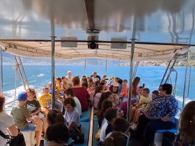 A lively group of children and adults enjoy a boat ride, creating memorable experiences on the water. Perfect for family outings and school trips.