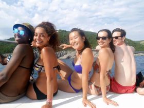 A joyful group of friends enjoys a sunny day on a boat, capturing the essence of fun and camaraderie on the water.