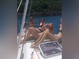 A lively group enjoys sunbathing on the deck of a yacht, capturing the essence of a fun day on the water with friends.