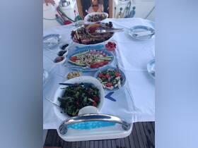 A beautifully arranged spread of fresh seafood and salads on a boat dining table, perfect for enjoying a gourmet meal while cruising on the water.