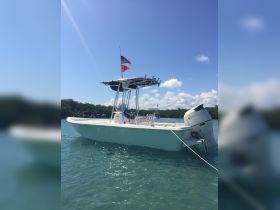 A pristine center console boat anchored in clear turquoise waters, showcasing its sleek design and readiness for adventure.