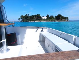 A bright and spacious interior view of a boat, showcasing comfortable seating and a clean design, perfect for relaxing on the water.
