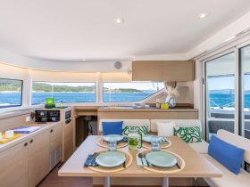 A beautifully designed interior of a boat featuring a cozy dining area with scenic views of the water, perfect for enjoying meals while cruising.