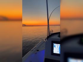A serene sunset view from the dashboard of a boat, showcasing the calm waters and vibrant sky — perfect for evening cruises and relaxation on the water.