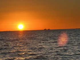A stunning sunset over the ocean, casting golden reflections on the water — a perfect backdrop for evening boat trips and romantic getaways.